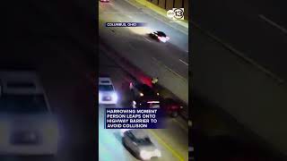 Harrowing moment person leaps onto highway barrier to avoid collision