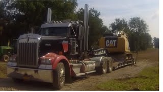 Kenworth W900 hauling a Cat 312E excavator