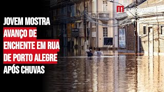 Jovem mostra avanço de enchente em rua de Porto Alegre após chuvas