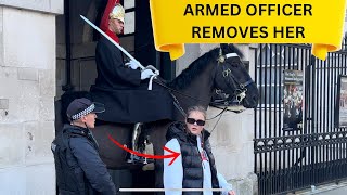 ARMED OFFICER QUICKLY REMOVES HER FOR UPSETTING THE KING’S GUARD HORSE