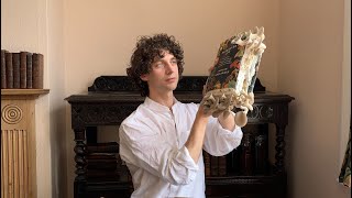 Merlin Sheldrake eats mushrooms sprouting from his book, Entangled Life