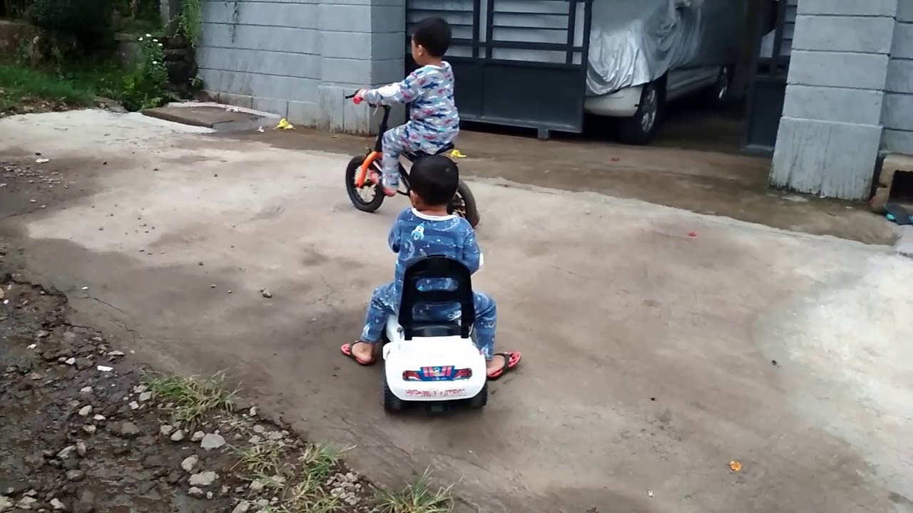  Anak  anak  bermain sepeda  dan mobil polisi  di jalanan 