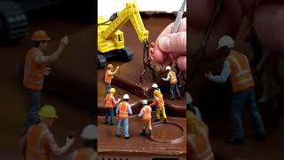 Tiny construction workers building a giant smartphone from chocolate, miniature cranes, realistic.