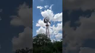Old fashion windmill pumping water from well.
