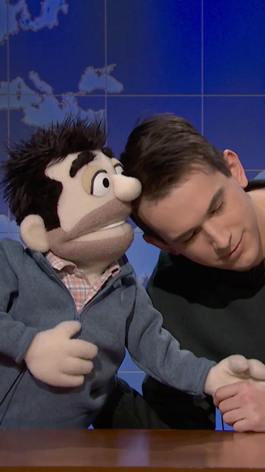 andrew and his puppet father perform their routine at the desk