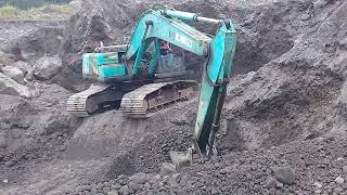 excavator loads and screens sand containing small stones - sand mining