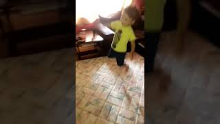 Boy jumps on mattress in living room and dog tackles him