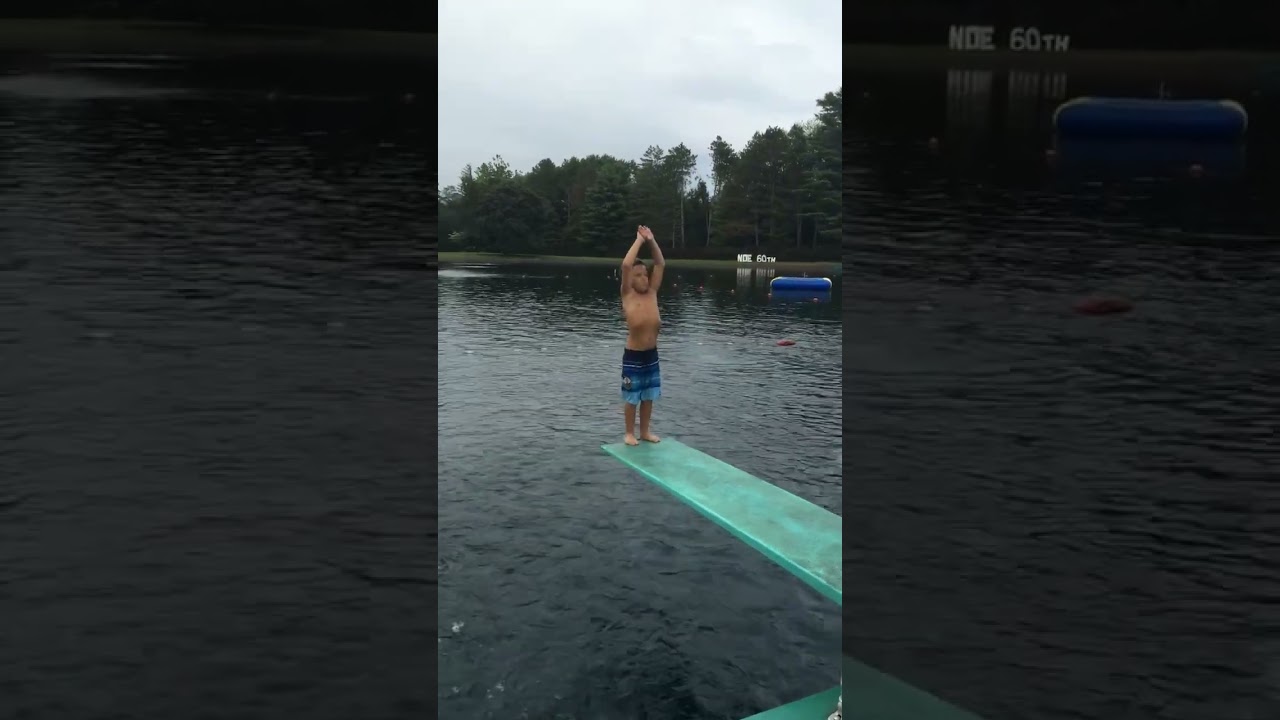 Little boy attempts backflip dive from diving board with no effort and falls into water