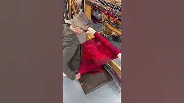 Weaver is cutting woven fabric off of the loom and making different items with it!