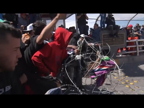 Migrants in Mexico break down police barricade near Texas border
