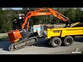 Excavator climbing to MUSTANG dump trailer (no ramps). Widest dumper range in the market