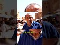 في قلب سوق القصبة النابض يظهر شيخ جزائري بوجهه المليء بالتجاعيد والمرح يحمل في يده الصغيرة