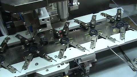 Oil seal trimming and spring loading machine