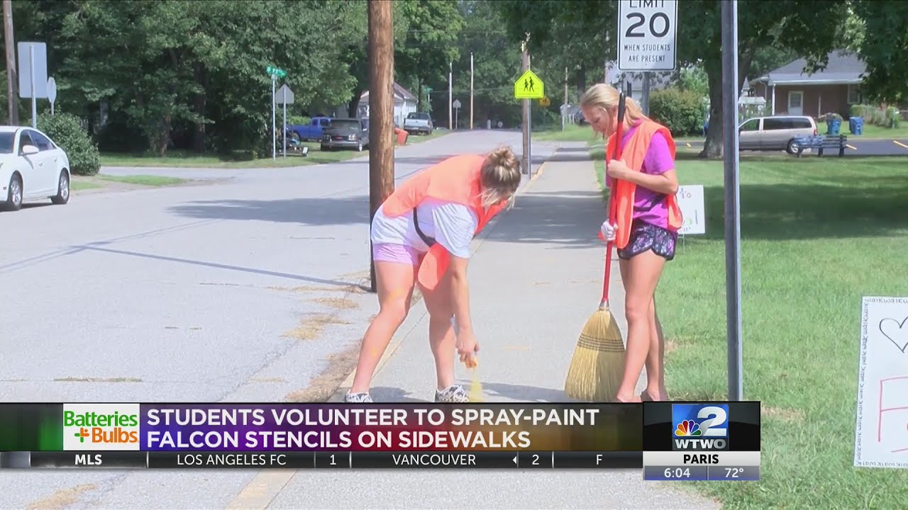 Volunteers spray paint sidewalks to indicate safe walking routes for