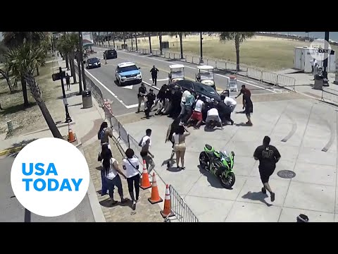 Heroic onlookers lift car to free trapped motorcyclist | USA TODAY