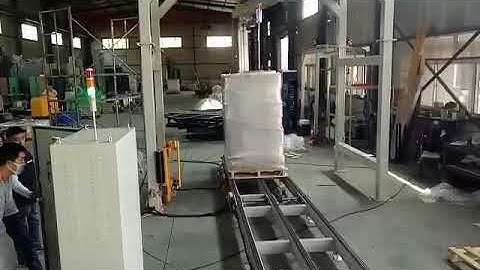 Rotary arm pallet wrapping machine
