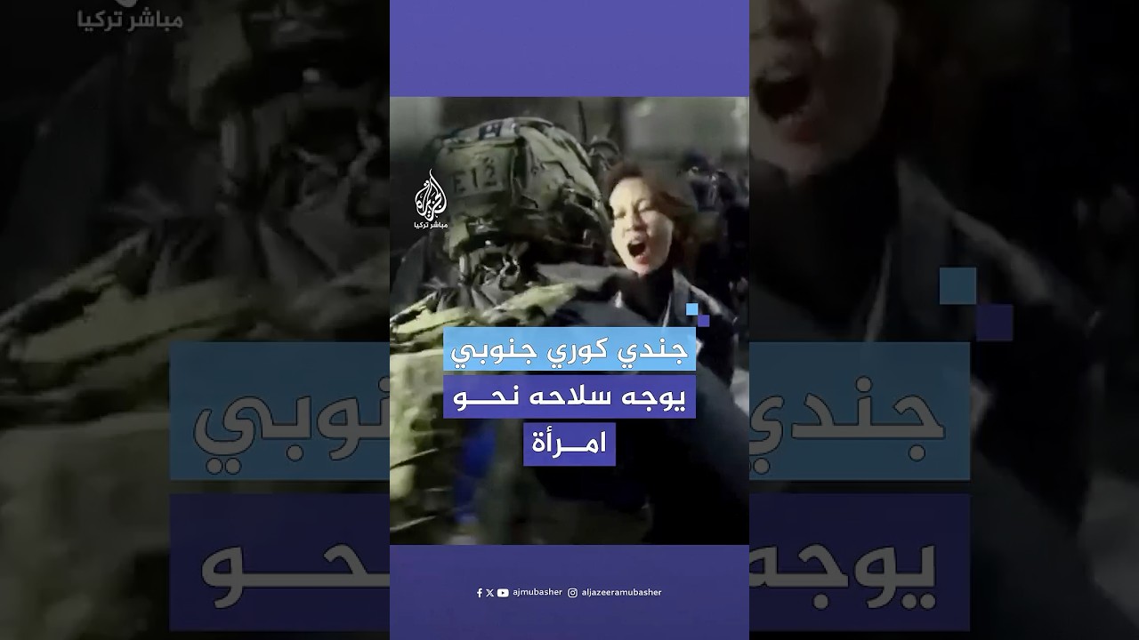 جندي كوري جنوبي يوجه سلاحه نحو امرأة في ساحة البرلمان عقب اقتحام قوات الجيش للمكان