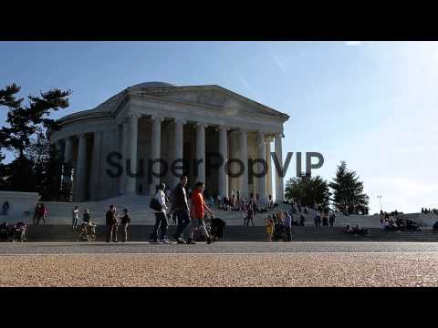 Tourists stroll by the Thomas Jefferson Memorial, dedicat...