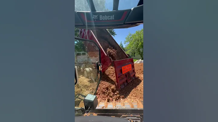 Huge dump truck dumping massive load of dirt