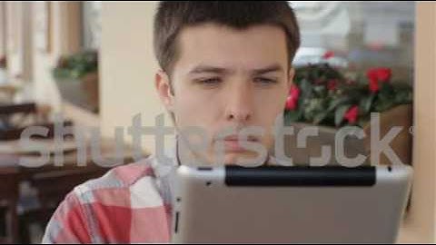 young man using tablet in cafe