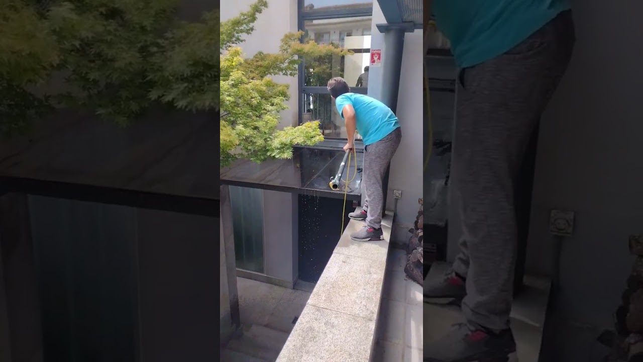 Limpieza de un techo de cristal en la entrada de un chalet
