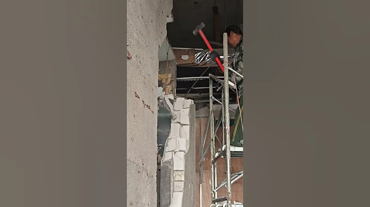 The process of using a hammer to demolish a wall