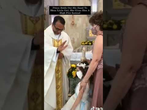 Priest holds out his hand to bless little girl, She gives him a high five instead