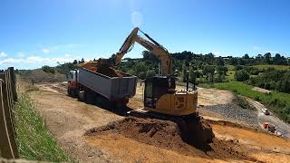 cat 310 excavator cutting batter and loading out 6 wheeler truck