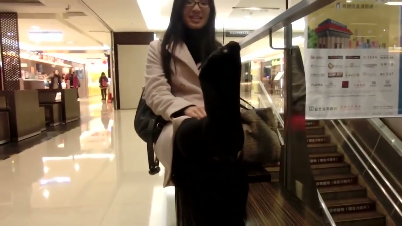 Attractive Asian sophisticated woman exposes her lovely feet at the shopping mall