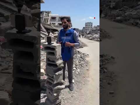 O jornalista palestino Moath Al-Kahlout é visto usando uma pilha de pedras