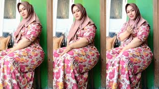 Beautiful hijab mother who has just cooked fried jengkol sits relaxed in front of the door