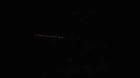 elon musk's shimmering trail of Starlink internet satellites trailed one after another in the sky