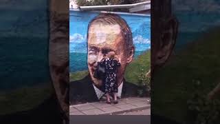 бабка гладит портрет Путина