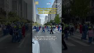 Kids run straight into traffic officer's arms when crossing road Update