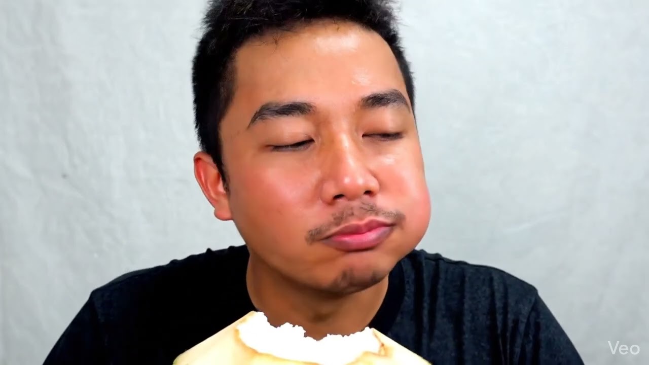 A person with a red face. Eating coconut with Fanta. 