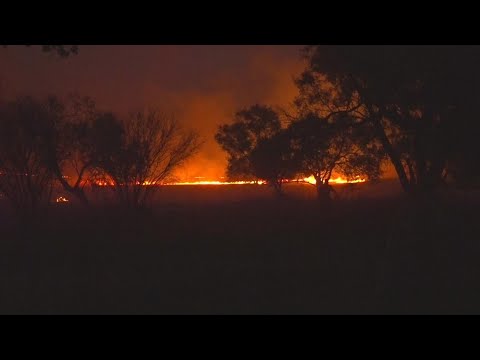 Fire crews working to contain large brush fire near oil business - YouTube