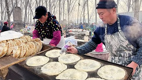 A 60-year-old couple sells biscuits at a rural gathering in Shandong - 天天要闻