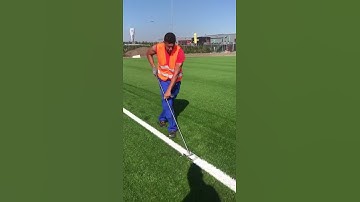 Installing the white lines of an artificial grass football pitch