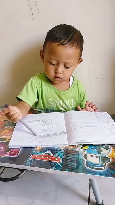 Bayi lucu coret coret buku pakai pensil