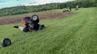 Woman on ATV jumps ramp then front wheels falls fall off on landing and she flips forward