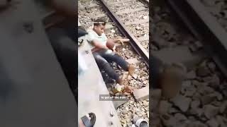 Dad lying on railroad tracks, over son, while a train passes in Bhairab, Bangladesh