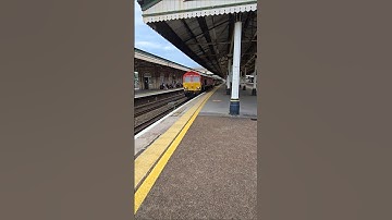 A DB Cargo Class 66 (66112) hauling 14 empty China Clay JIAs through Platform 4 at Exeter St Davids