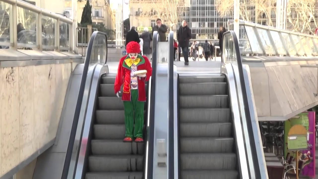 Clown rides an escalator