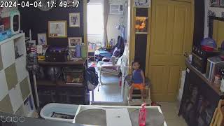 Boy sitting on step stool with cat falls over and does a sideways scorpion (Security camera)