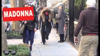 Madonna walks around on crutches in the winter cold in NYC