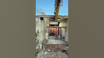 The process of an excavator removing a complete cement slab on a roof