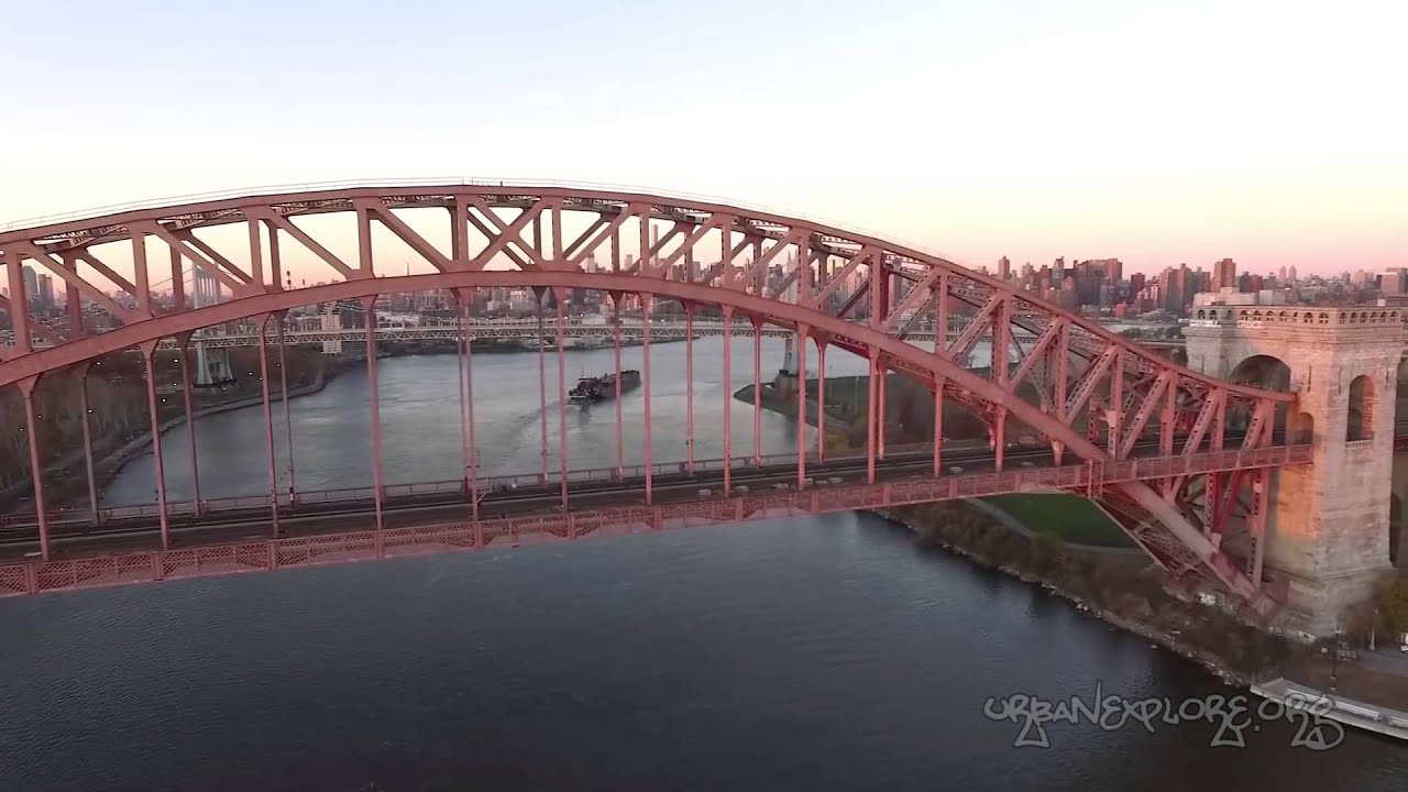 NYC Hell Gate Bridge Queens Train - drone aerial fly over Manhattan New York City