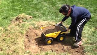 Teghvir using his Tonka trucks for dumping dirt