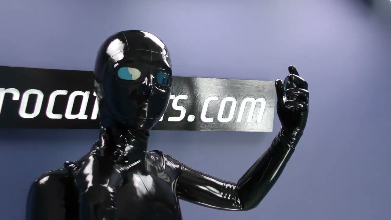 Looking at herself in mirror - in latex catsuit and mask with mirror lens from Eurocatsuits