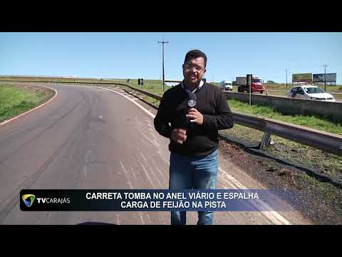 Carreta tomba no anel viário e espalha carga de feijão na pista